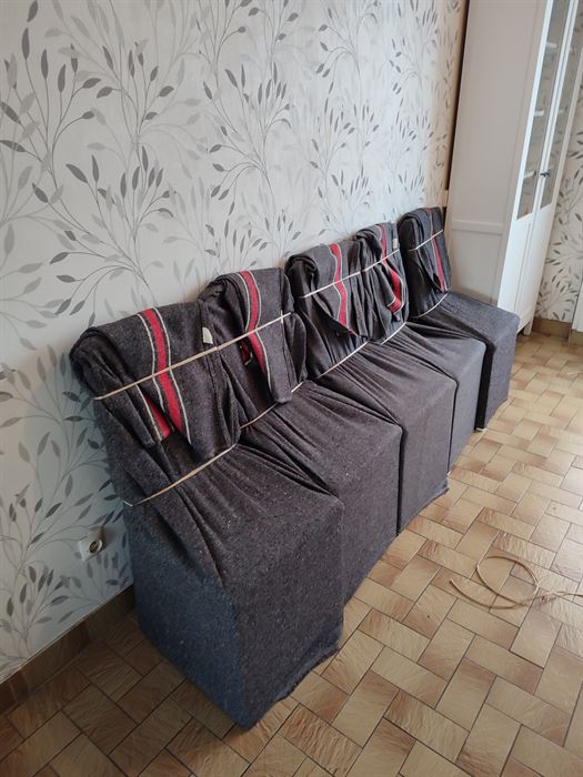 Fauteuils entièrement houssés de couvertures de déménagement et cerclés avant le portage